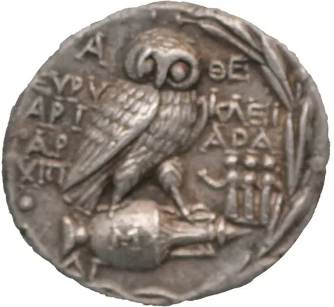Reverse of an Athenian "New Style" silver tetradrachm, ca. 200-150 BCE, showing an owl standing on an amphora within an olive wreath. Photo: MatthiasKabel / Wikimedia Commons, CC BY-SA 3.0.