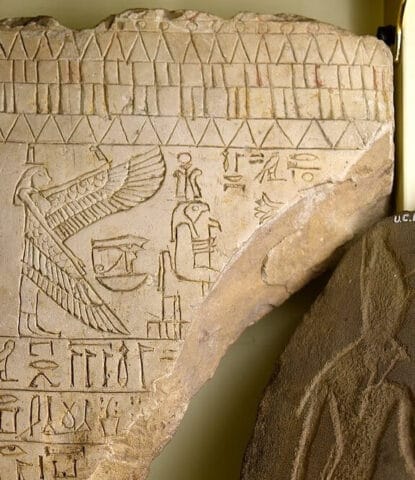 Ra-Horakhty seated with the goddess Isis behind him on an ancient Egyptian limestone stela. Petrie Museum of Egyptian Archaeology, UCL. Image via Wikimedia Commons, CC BY-SA 4.0.