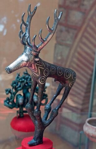 Hattian bronze stag standard (c. 2200 BCE), a ceremonial ornament likely mounted on a royal or cult staff, representing the importance of animal imagery in early Anatolian religious traditions. Excavated from the royal tombs at Alaca Höyük. Photo: Dosseman, Wikimedia Commons, CC BY-SA 4.0.